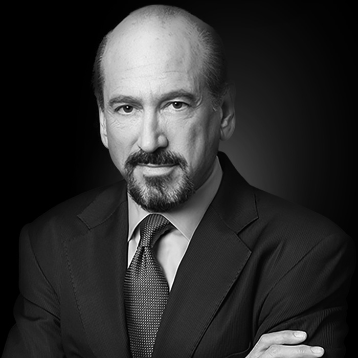 Photo of Mike Sitrick standing with arms crossed on black background